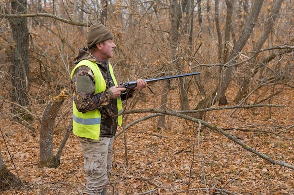 Myśliwy w kamuflażu z pistoletem