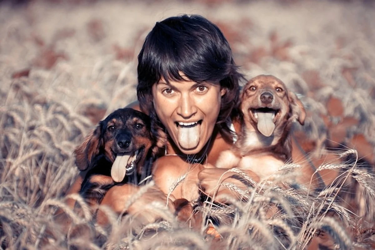 Młoda kobieta z dwoma psami wywieszonymi językami