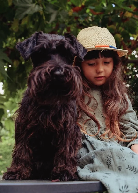 Dziewczyna siedząca z czarnym małym psem