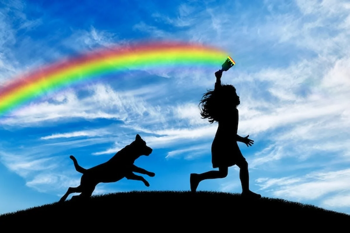 Dziewczynka z pędzlem rysuje tęczę z psem